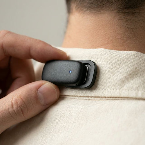 Close-up of Posture Pulse being clipped onto shirt collar showing magnetic mechanism