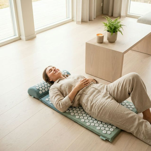 Woman relaxing on Physia acupressure mat in bright Scandinavian living room
