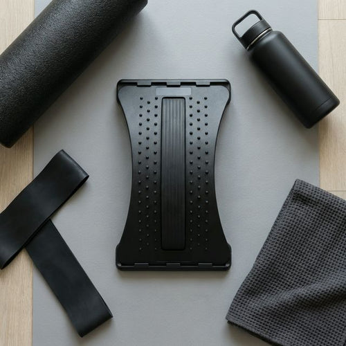 Flat-lay of back stretcher with foam roller, resistance band, and water bottle